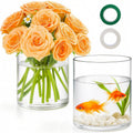 Clear glass cylinder vase set with green floral stems and fish decoration inside