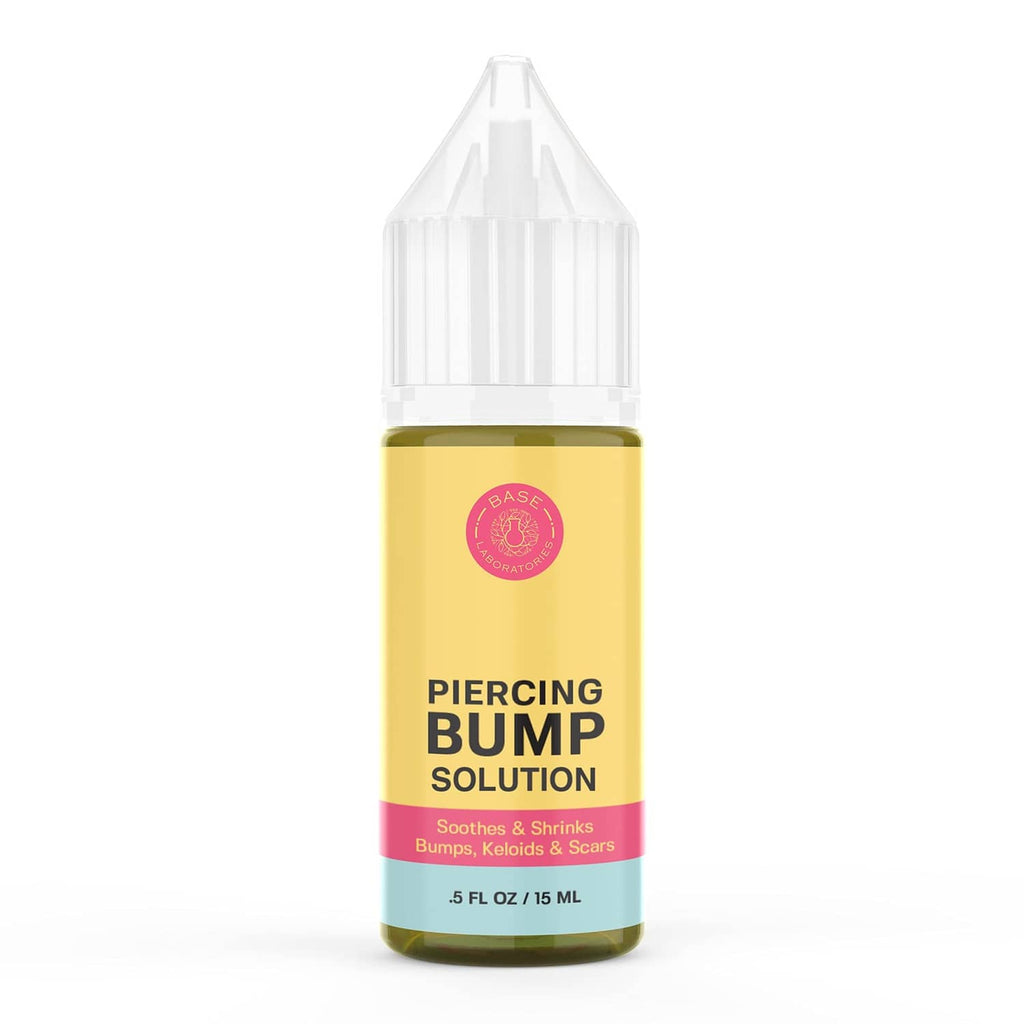 Piercing bump solution bottle with yellow liquid and white flip-top nozzle.