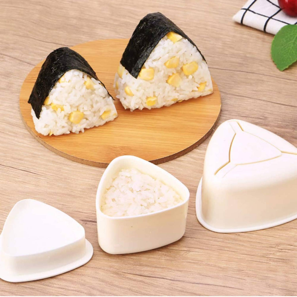 Triangle onigiri molds and two filled rice triangles with nori on a wooden board
