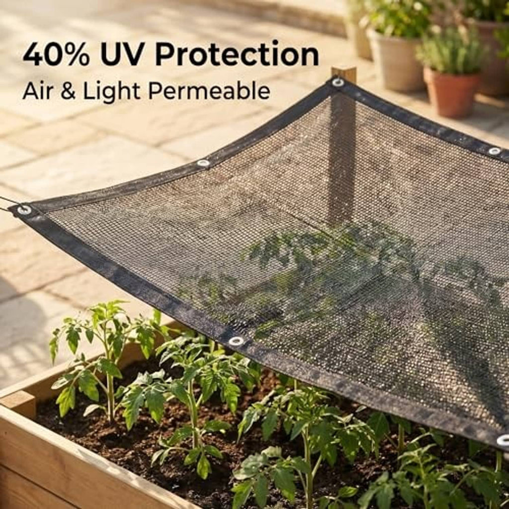Dark gray mesh sun shade cloth stretched over garden bed with grommets at corners