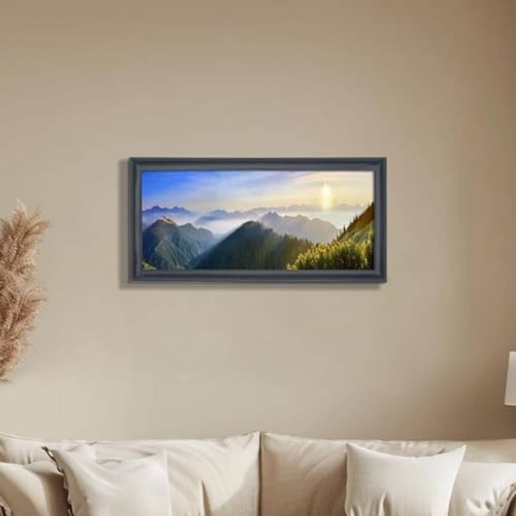 Black panoramic photo frame hanging on a wall above a sofa