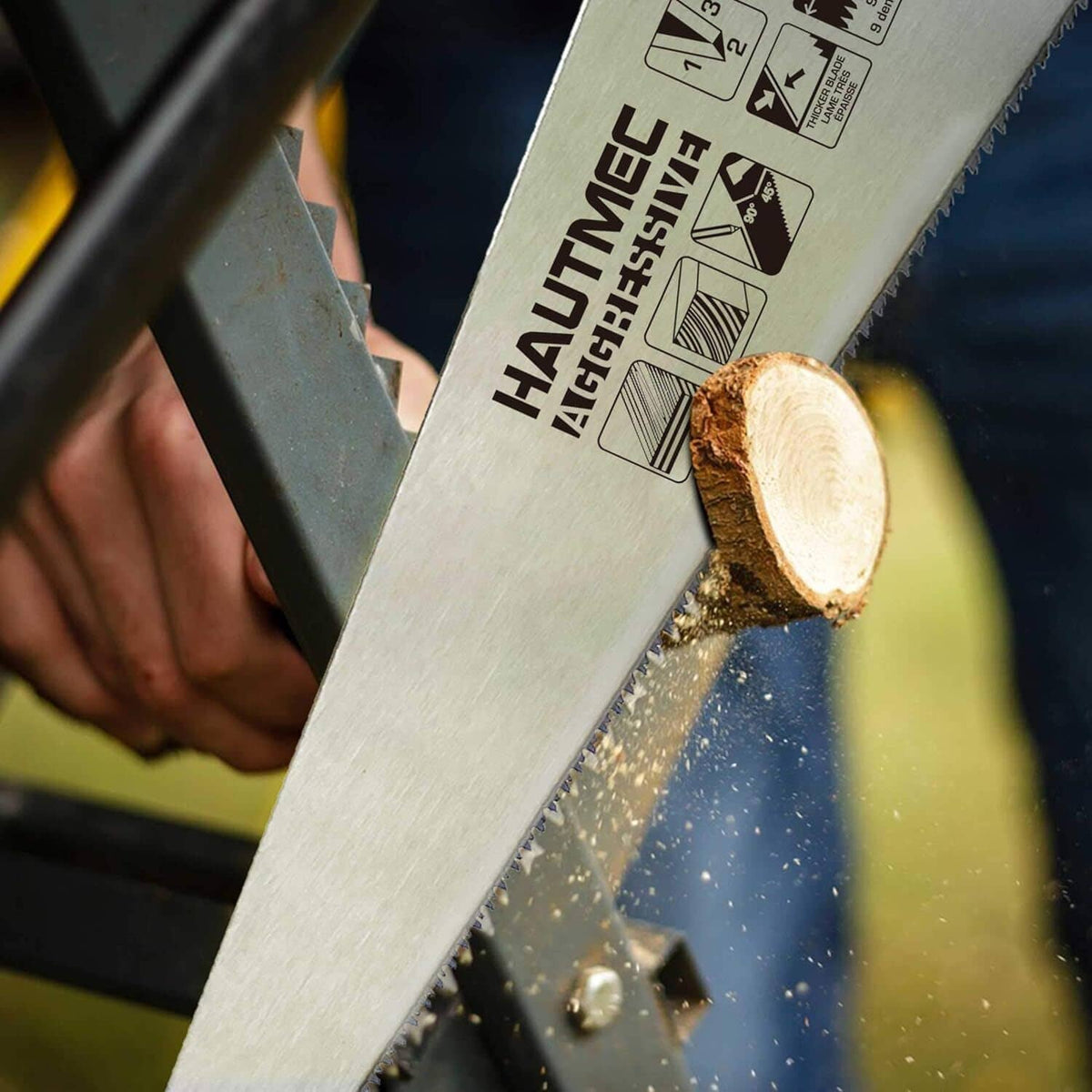 Multicolor hand saw cutting through a wooden log with saw teeth visible