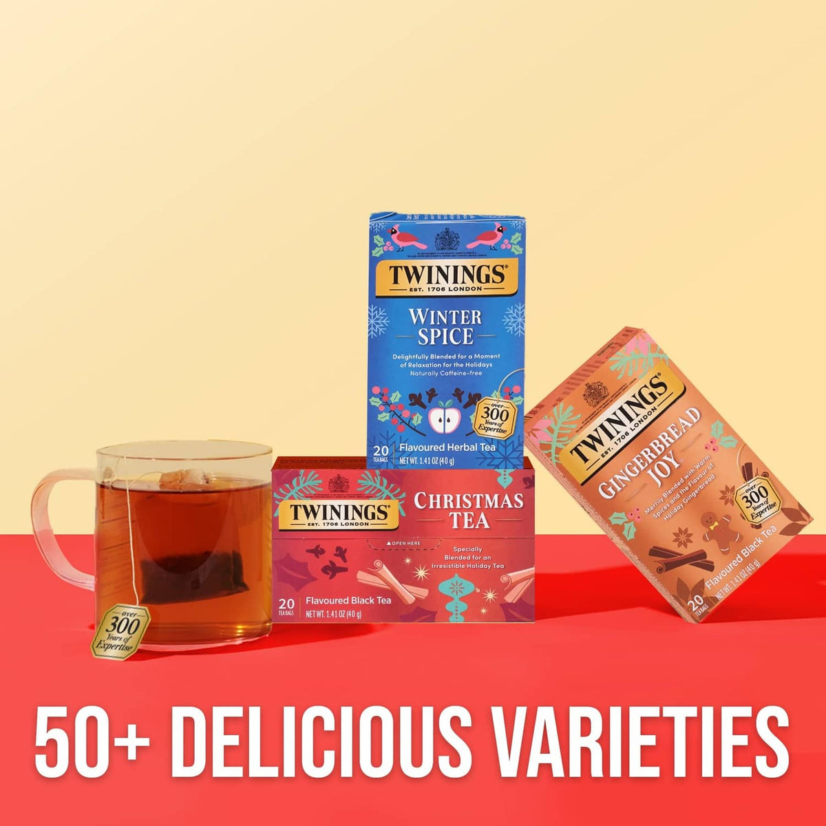 Twinings tea assortment featuring a Christmas Tea red carton beside a cup of spiced tea.