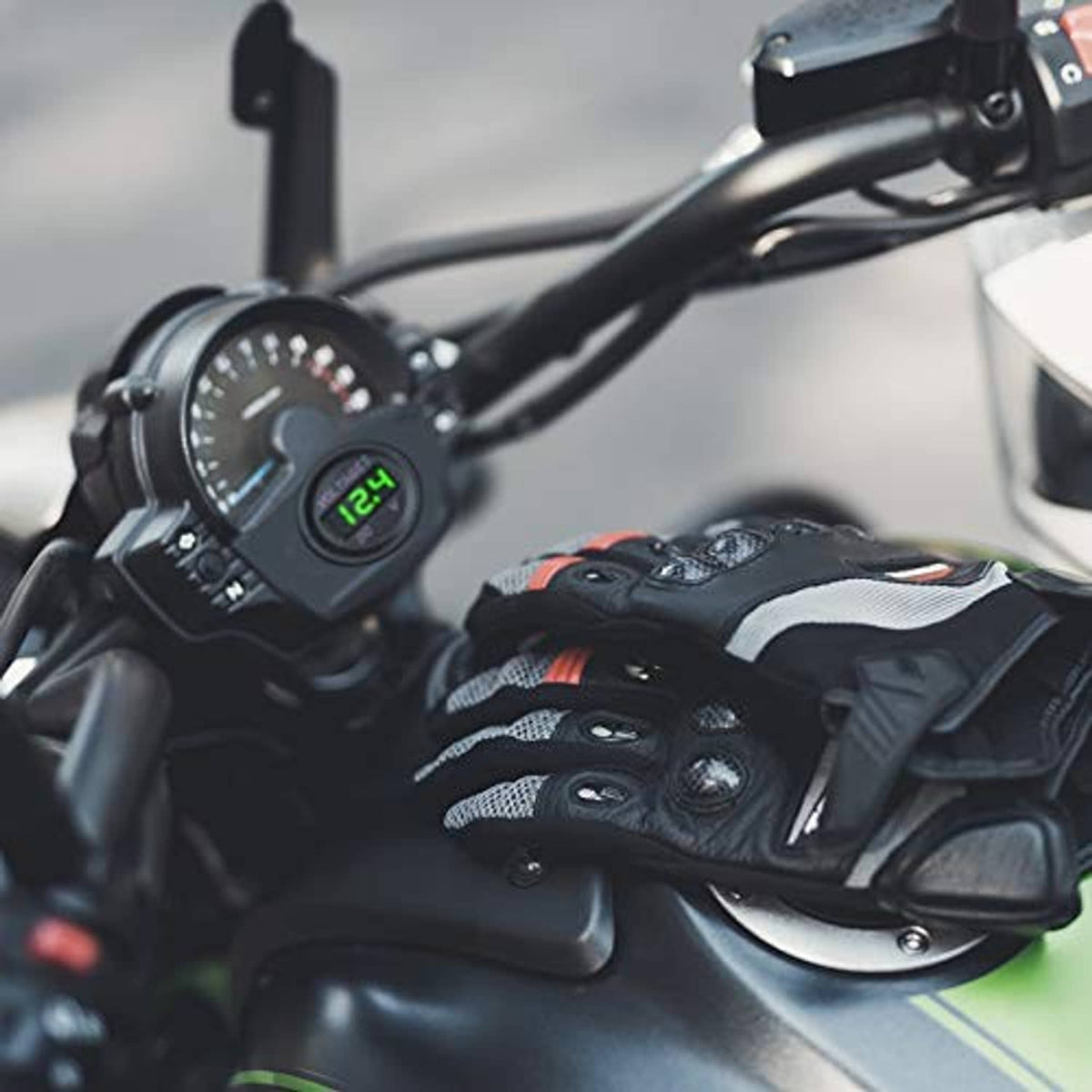 Round DC voltage gauge installed on a vehicle handlebar, green LED display on
