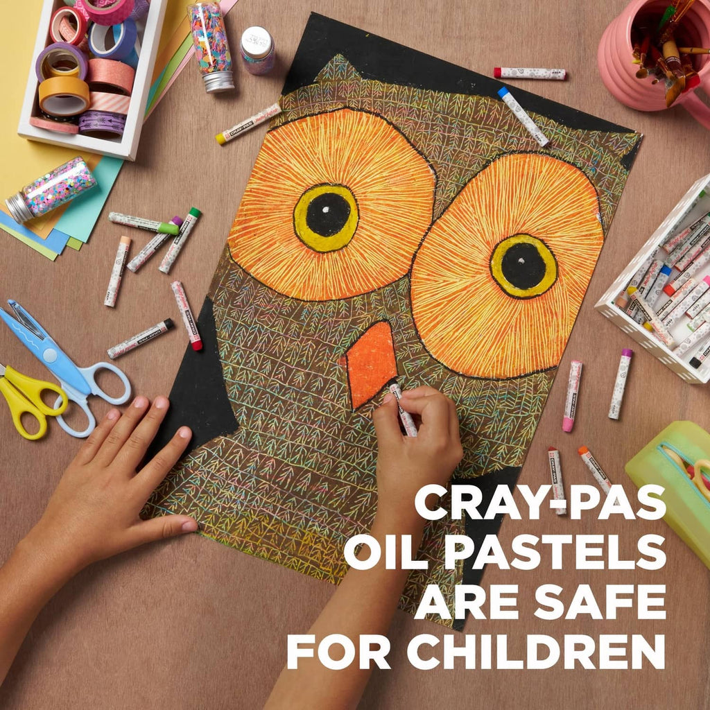 Oil pastel crayons in use, hands coloring an owl drawing on dark paper