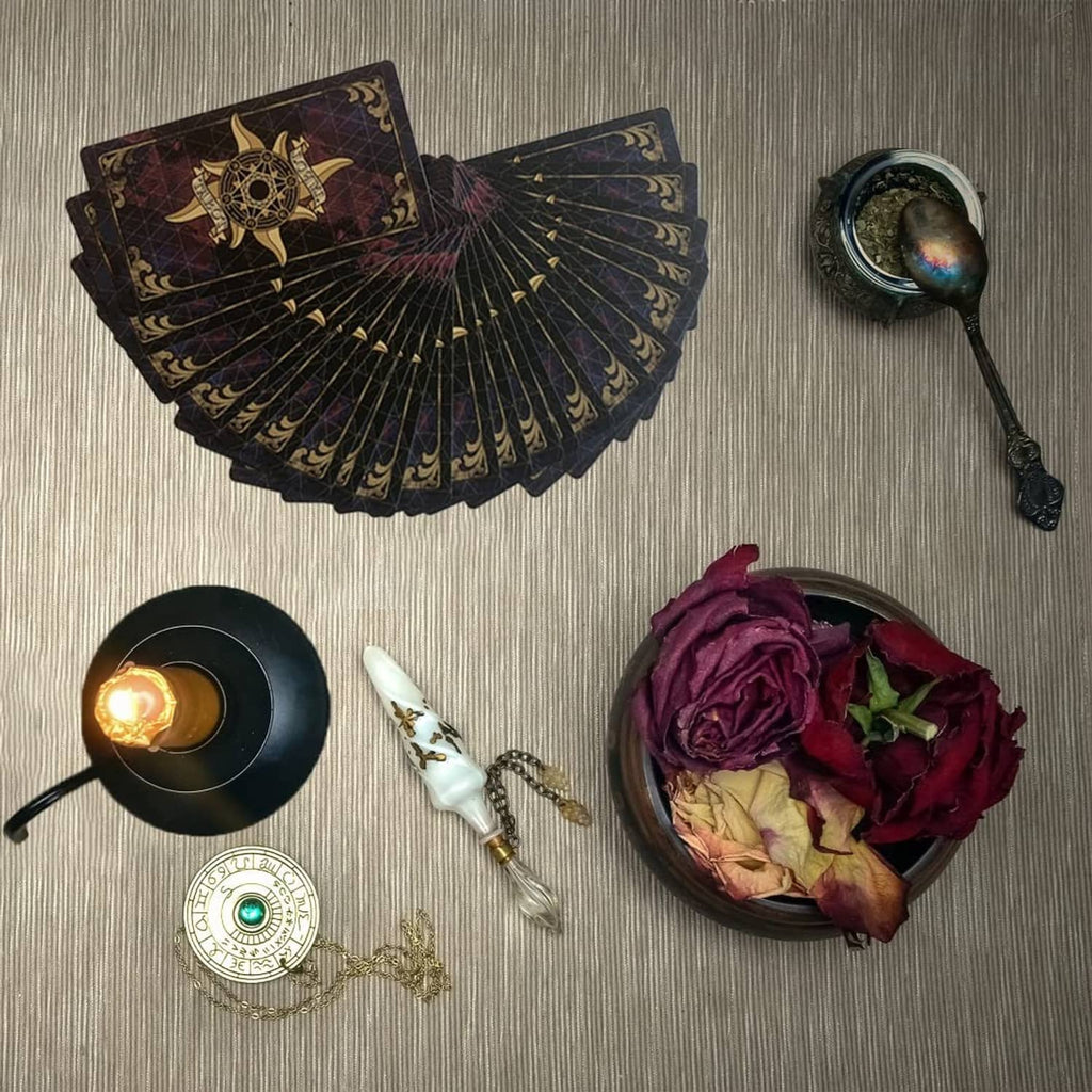 Pile of tarot cards with dark ornate backs and gold emblem design