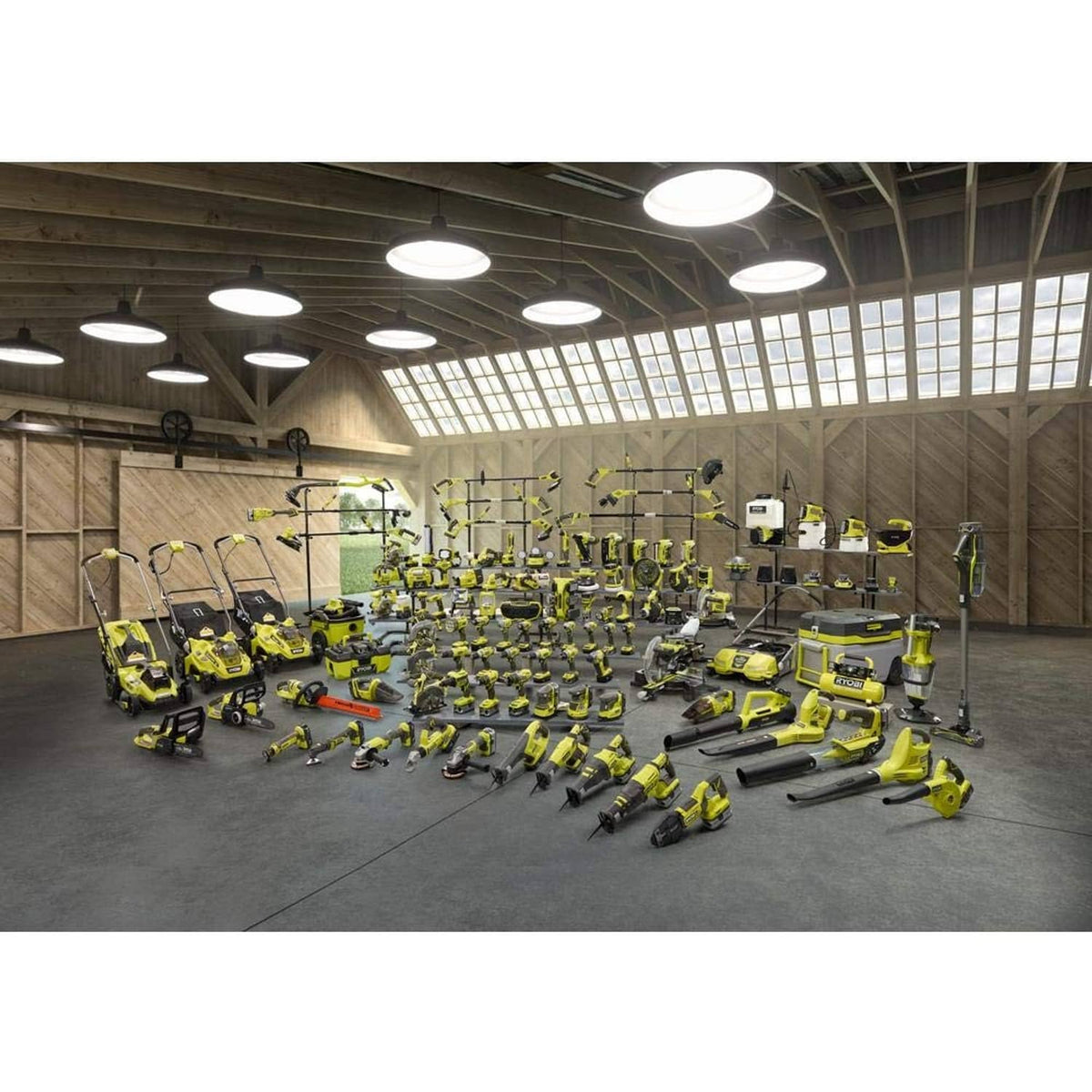 Wall display of multiple green Ryobi cordless tools and accessories