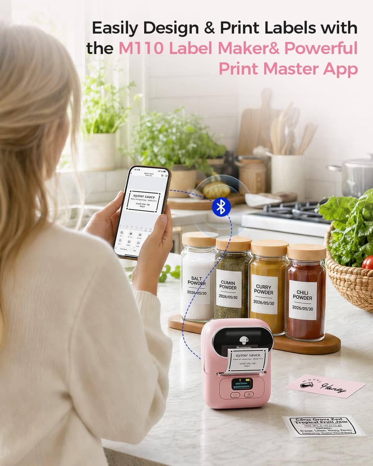 Pink Phomemo M110 label printer on table with printed label strip.