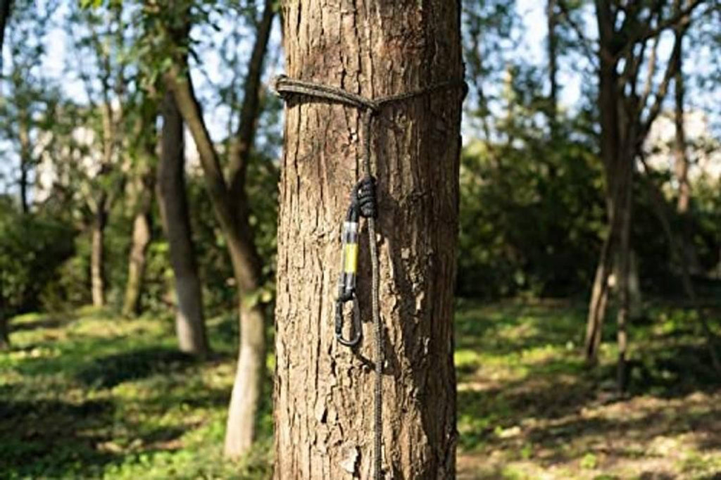 Treestand safety rope with carabiner attached to tree trunk, dark braided cord and yellow label