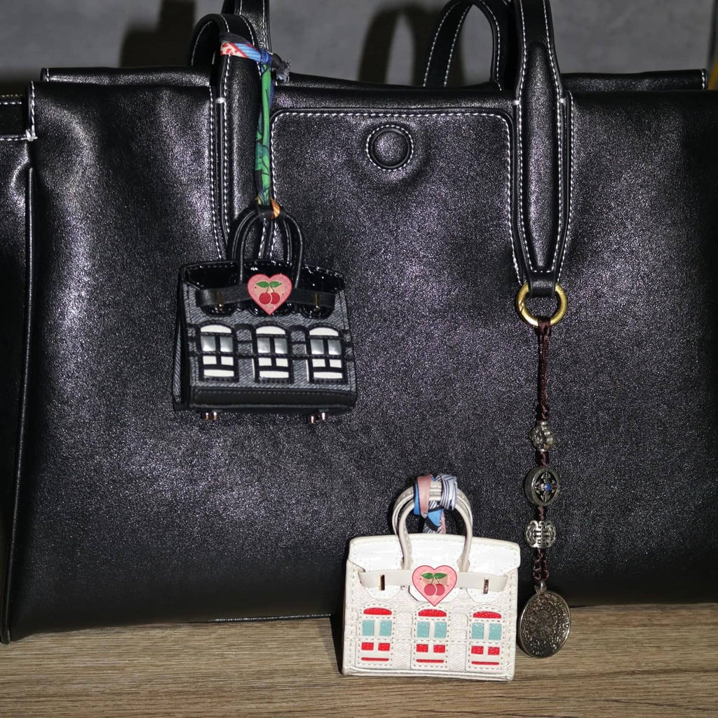 Black mini backpack keychain pouch and white mini backpack keychain pouch with heart charms.