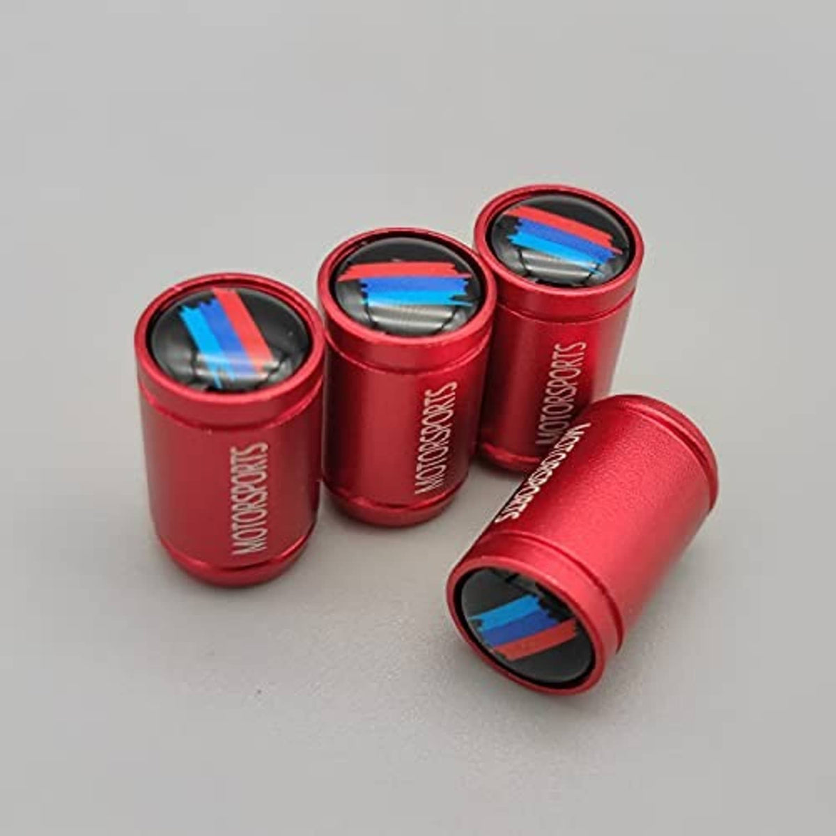 Red valve stem caps set with blue stripe accents on black-lined openings