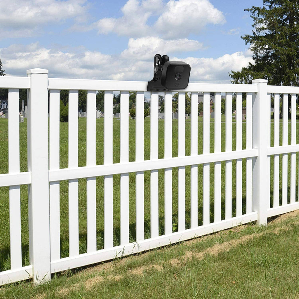Black clip clamp mount with camera attached to a white picket fence