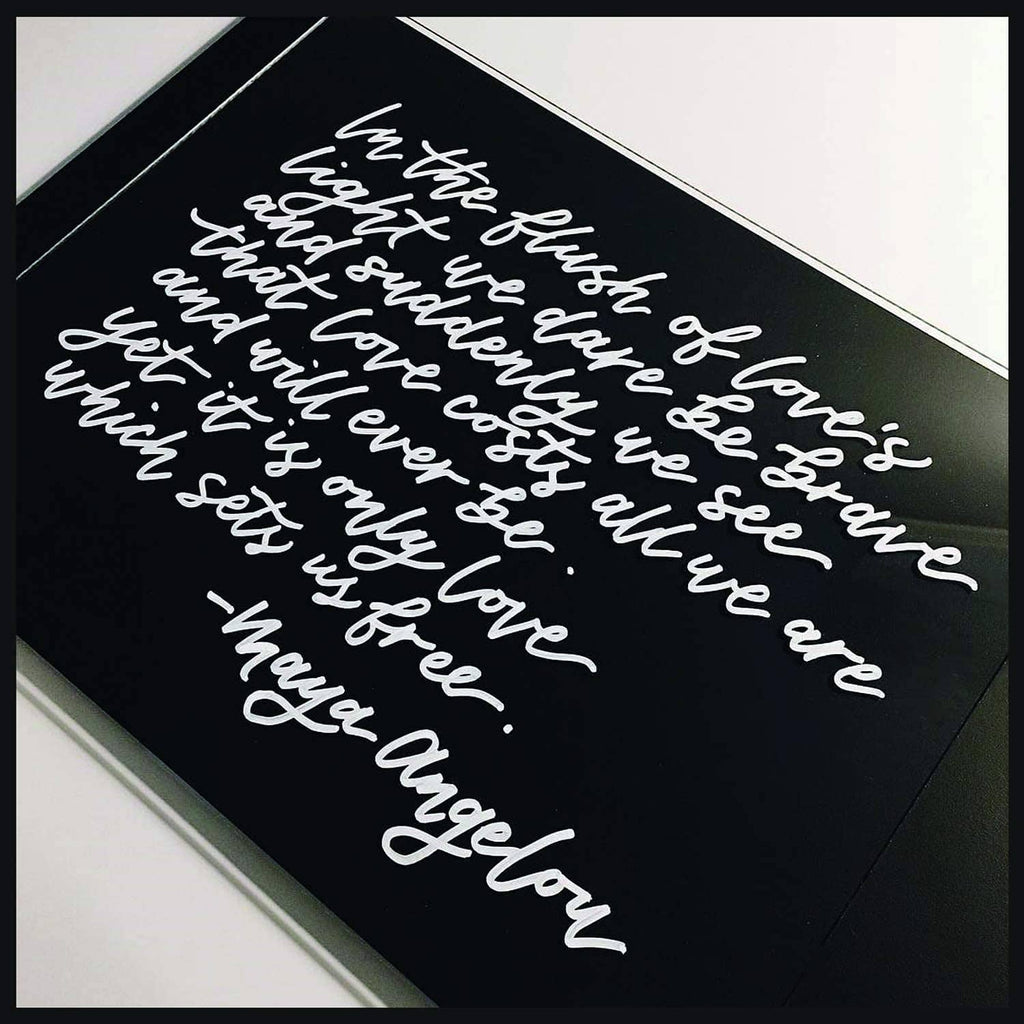 Paint pen lettering on dark paper with white cursive script and small accents