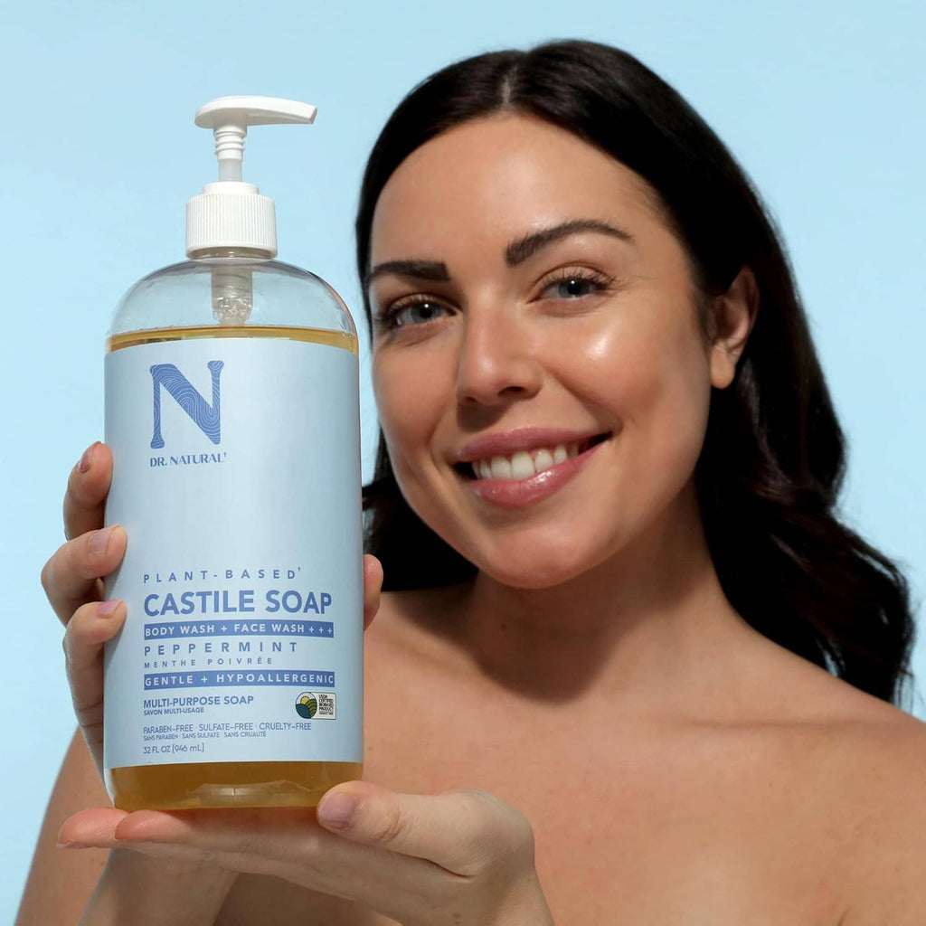 Castile liquid soap bottle held beside face, peppermint label, white pump dispenser.