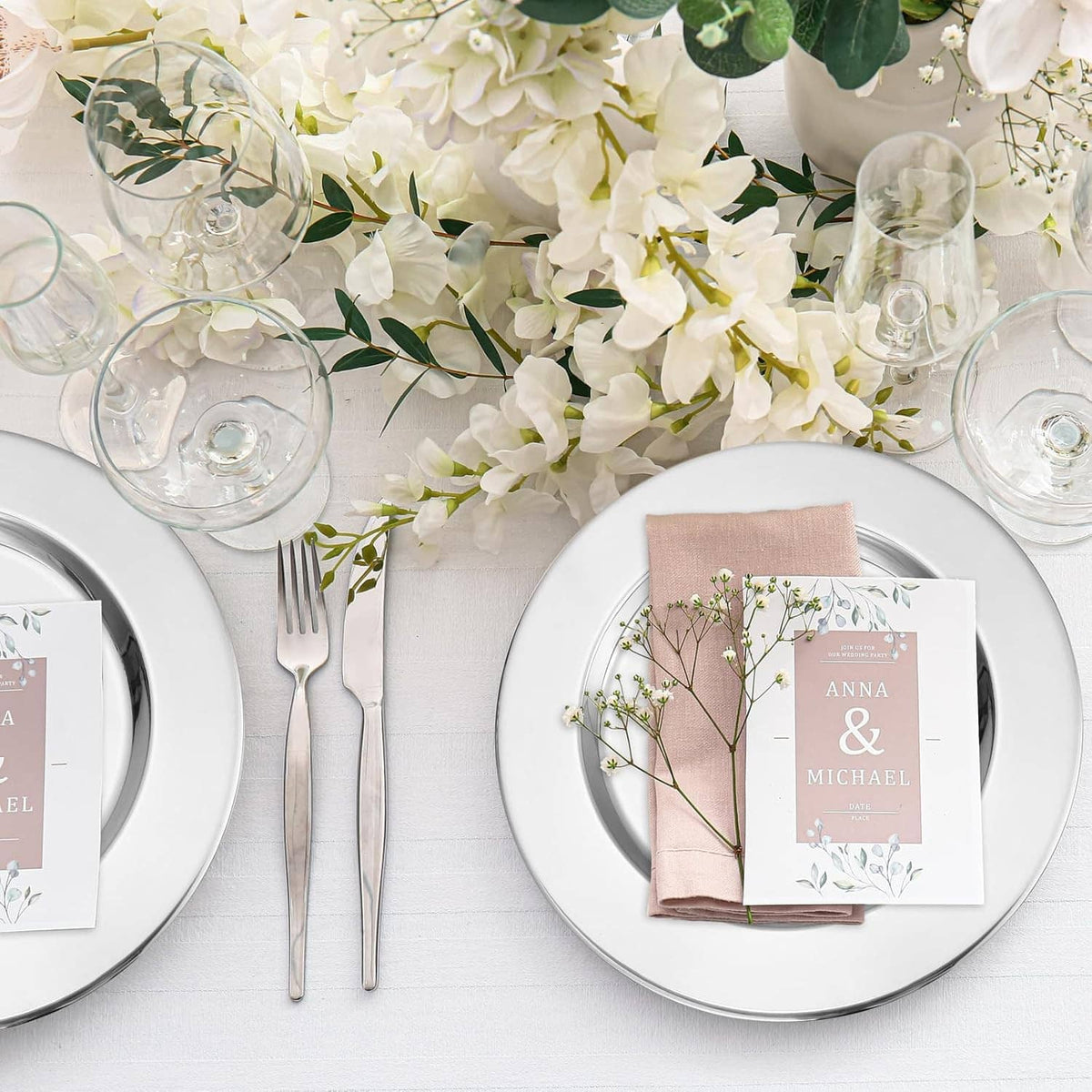 Round silver stainless steel charger plate with floral centerpiece and place cards