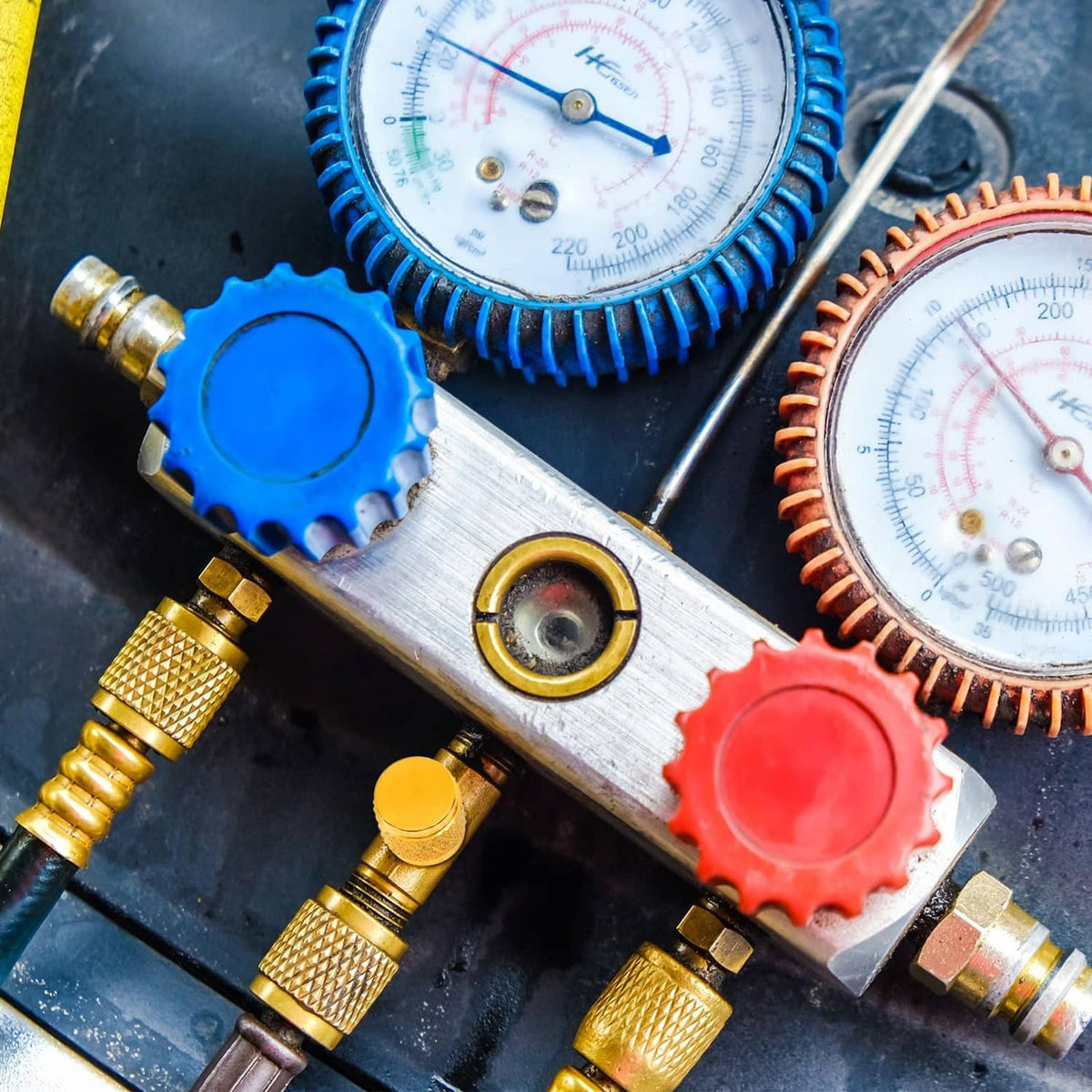 Brass HVAC valve caps with knurled grip and neoprene o-ring seals on gauge manifold