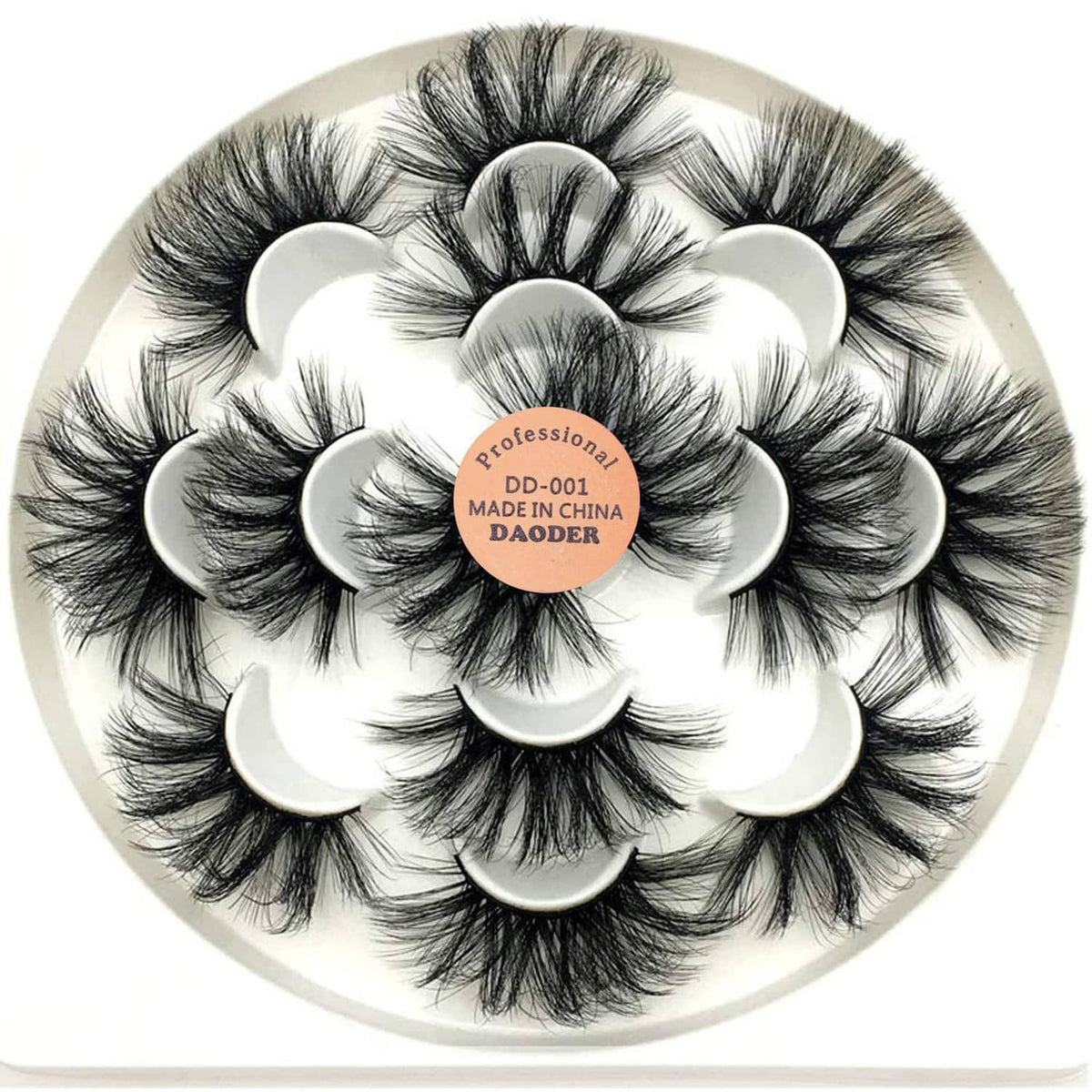 Dramatic long black faux mink-style false eyelashes on a circular tray with label.
