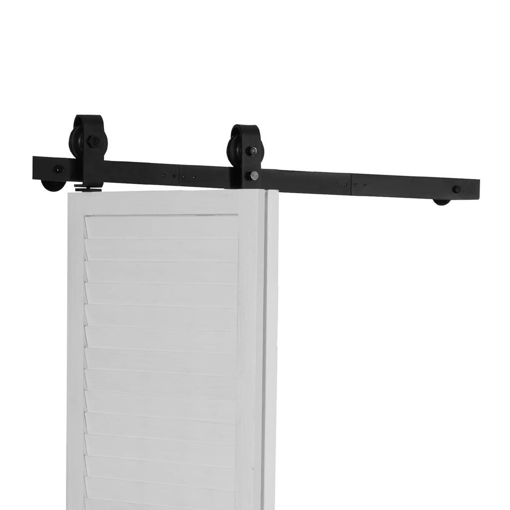Black sliding barn door track assembly with roller brackets on white door