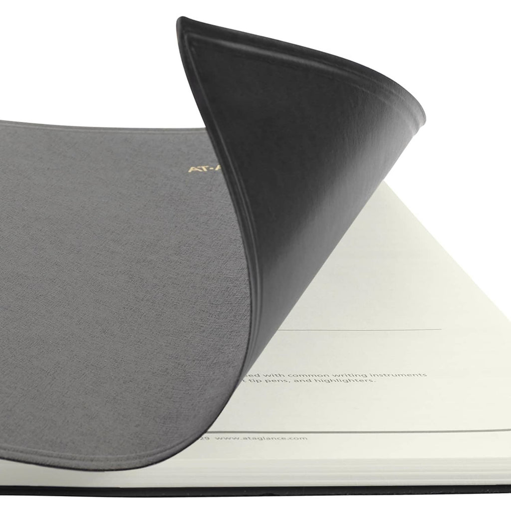Black planner cover with rounded corner, stitched edge, and partial AT-A-GLANCE mark