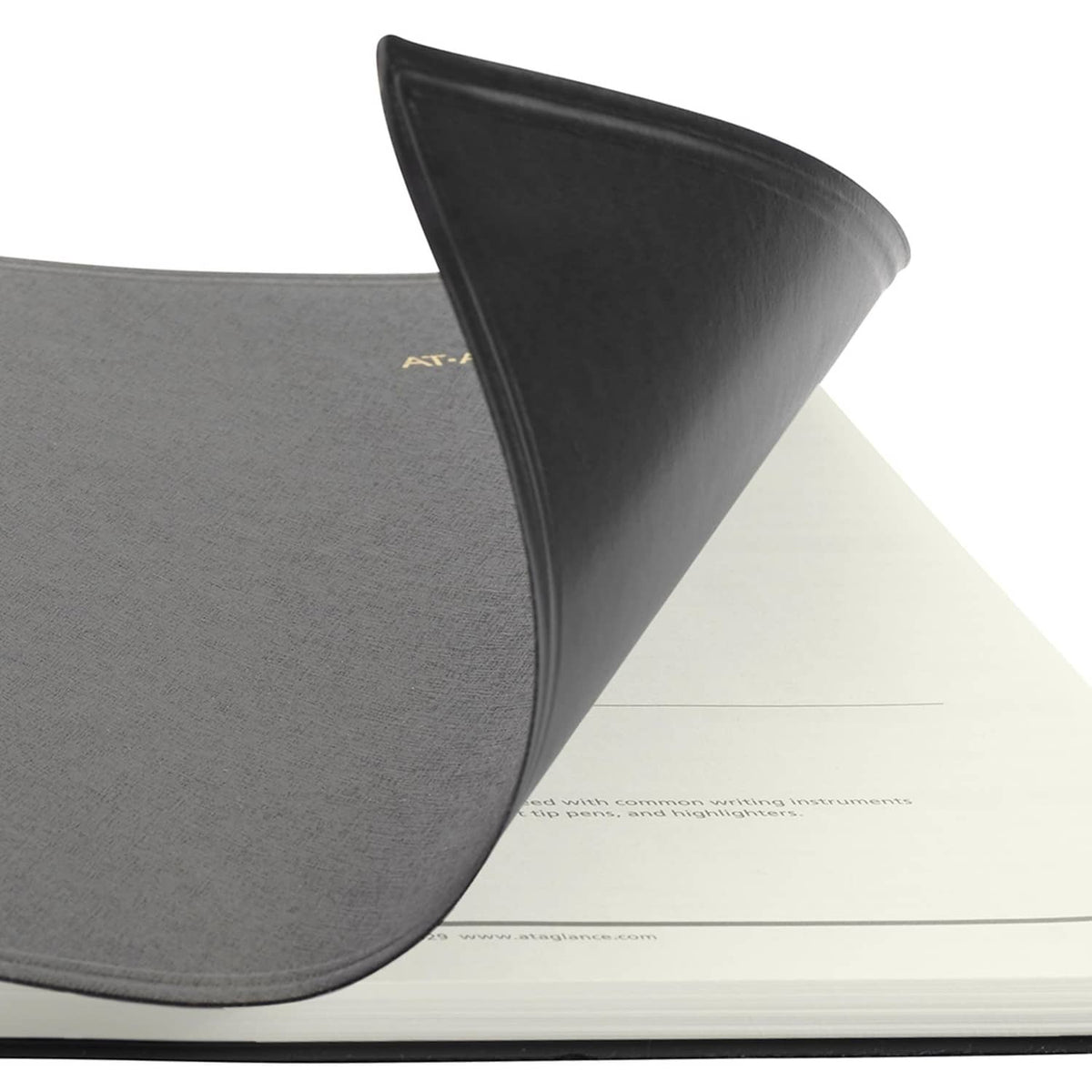 Black planner cover with rounded corner, stitched edge, and partial AT-A-GLANCE mark