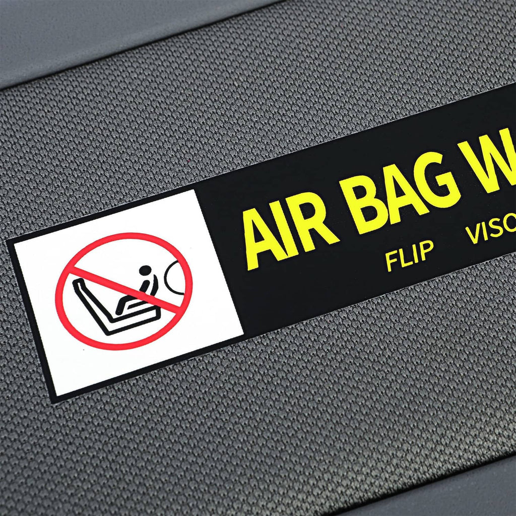 Close-up of dark gray sun visor warning label with yellow “Air Bag Warning” text