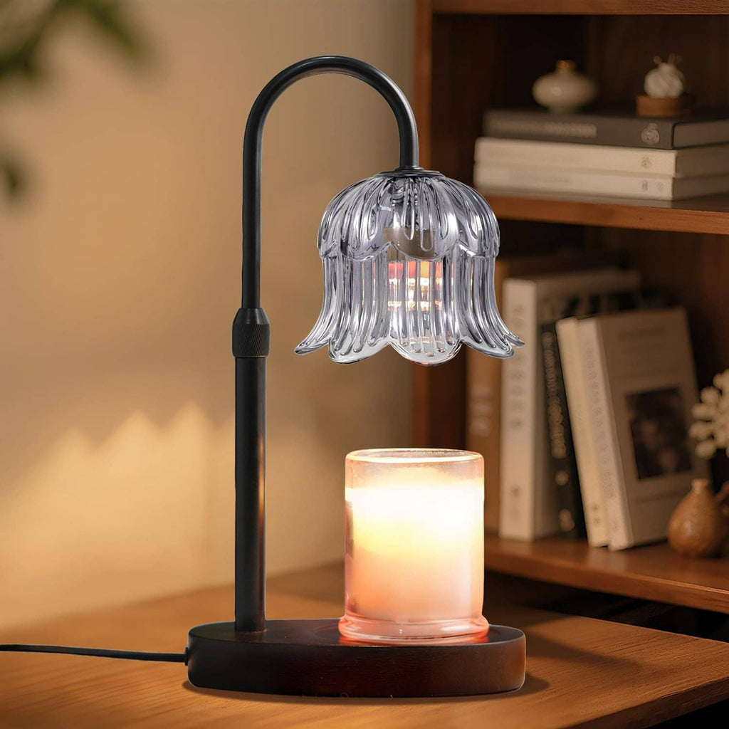 Black candle warmer lamp with ribbed glass shade and glowing candle on round base