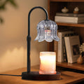 Black candle warmer lamp with ribbed glass shade and glowing candle on round base