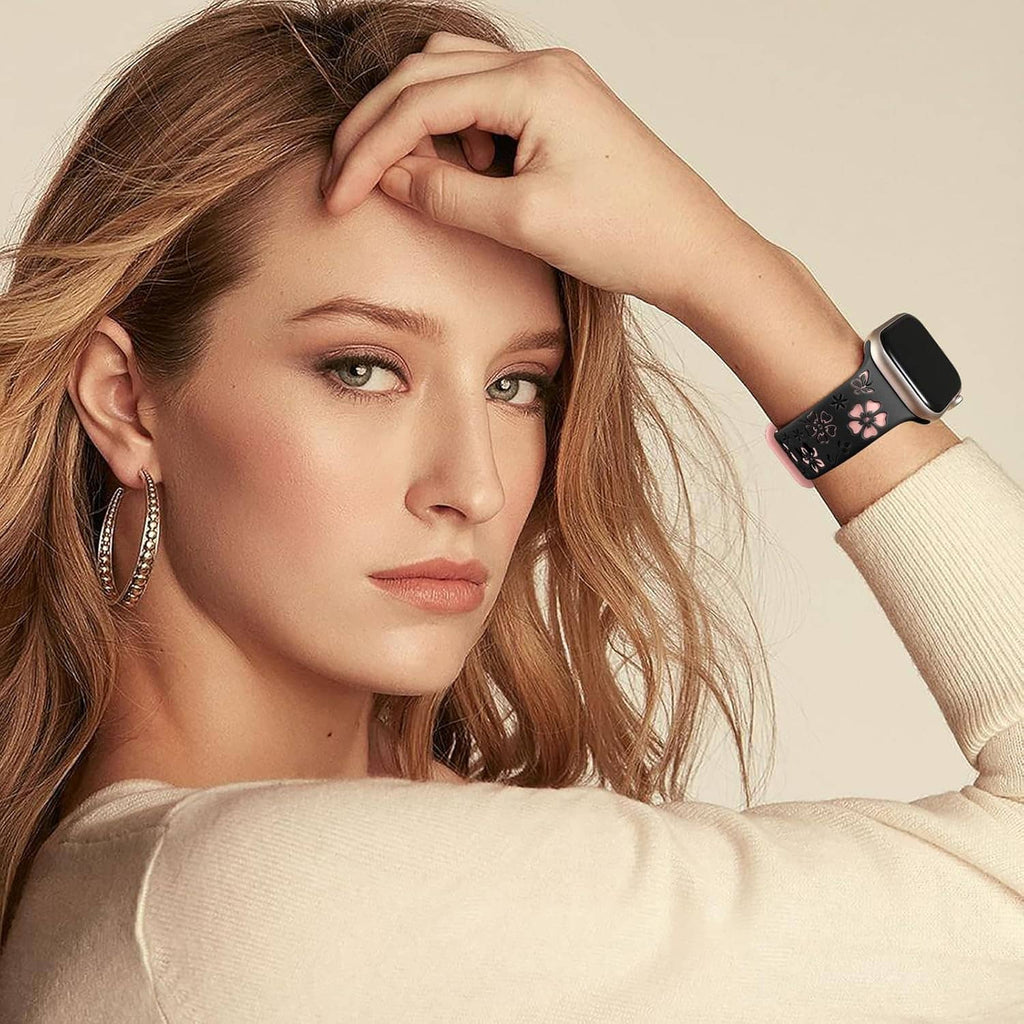 Floral engraved smartwatch band with pink floral design on black band, worn by woman