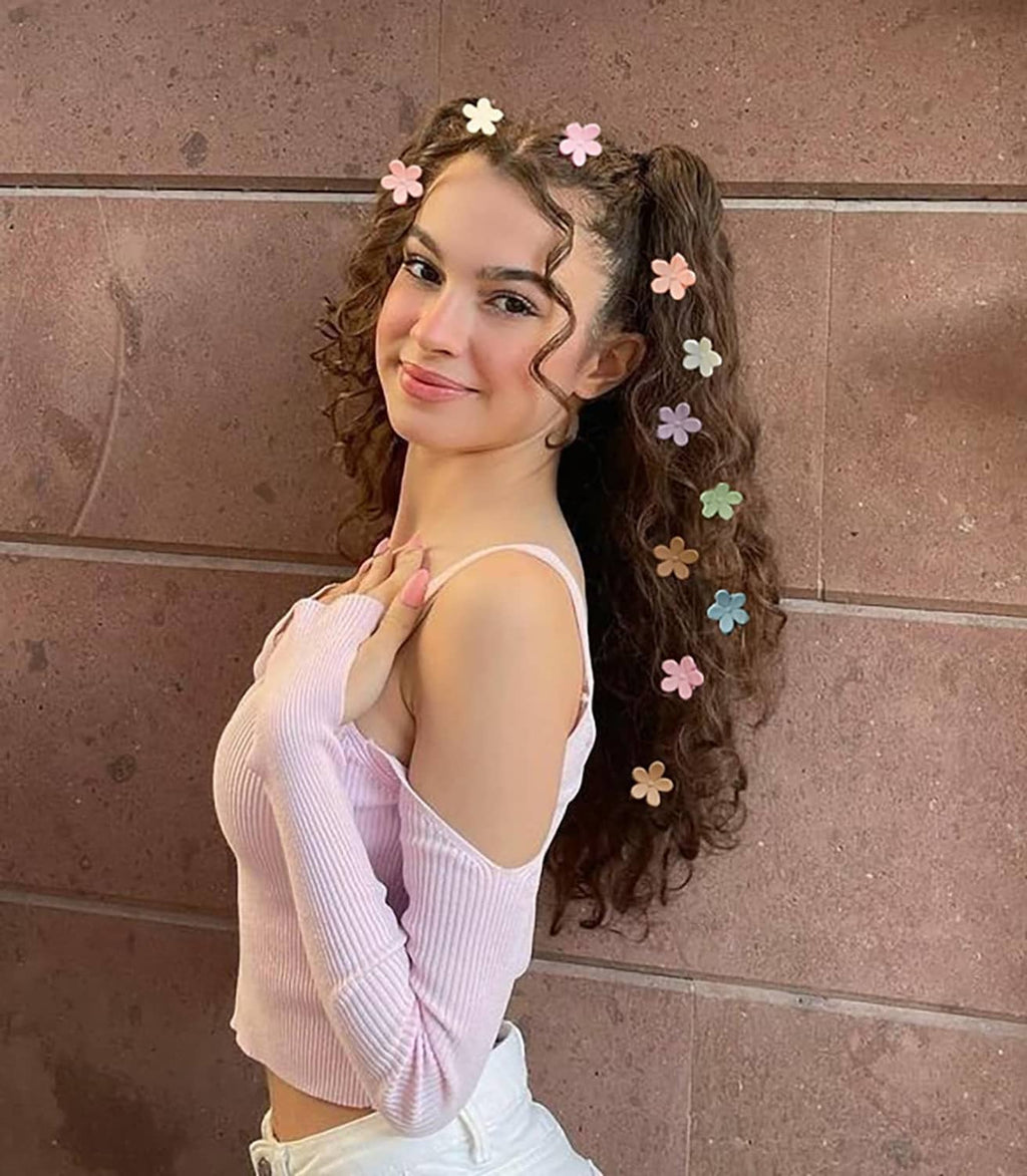 Small flower hair clips on dark curly hair, decorative row of pastel blossoms