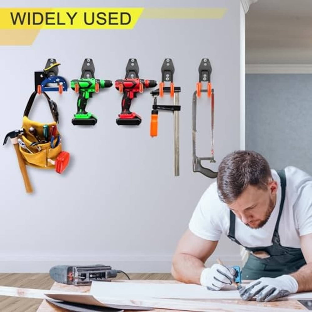 Black U hooks mounted on a wall holding hand tools in a workshop