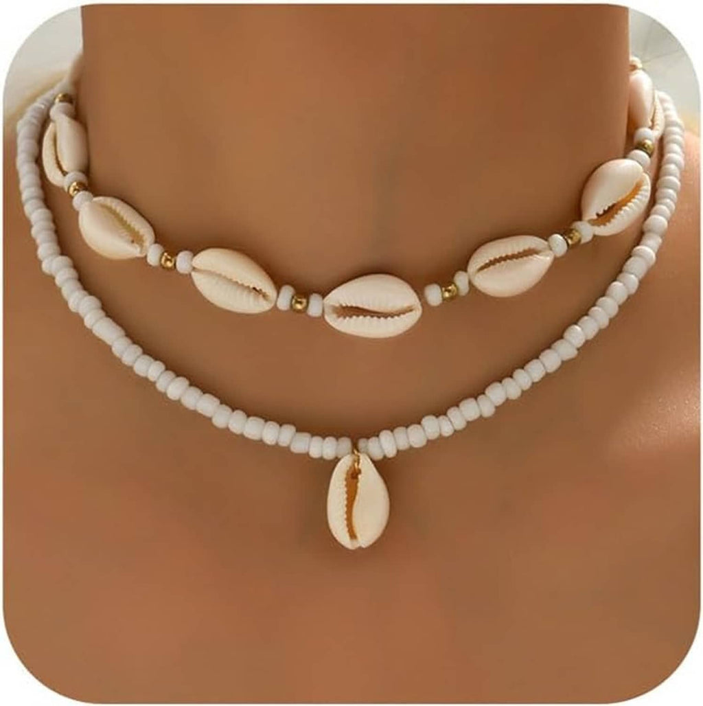 Handmade sea shell necklace featuring white bead strands, cowrie shells, and gold-tone accents