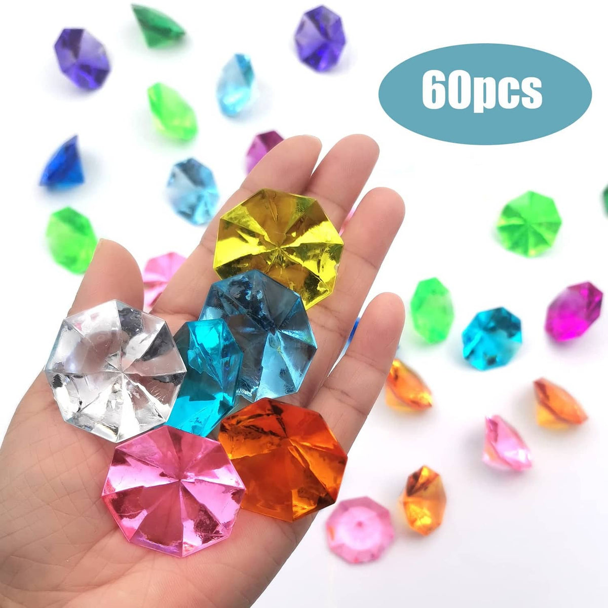 Multicolor faceted acrylic diamond gems shown with a hand for size