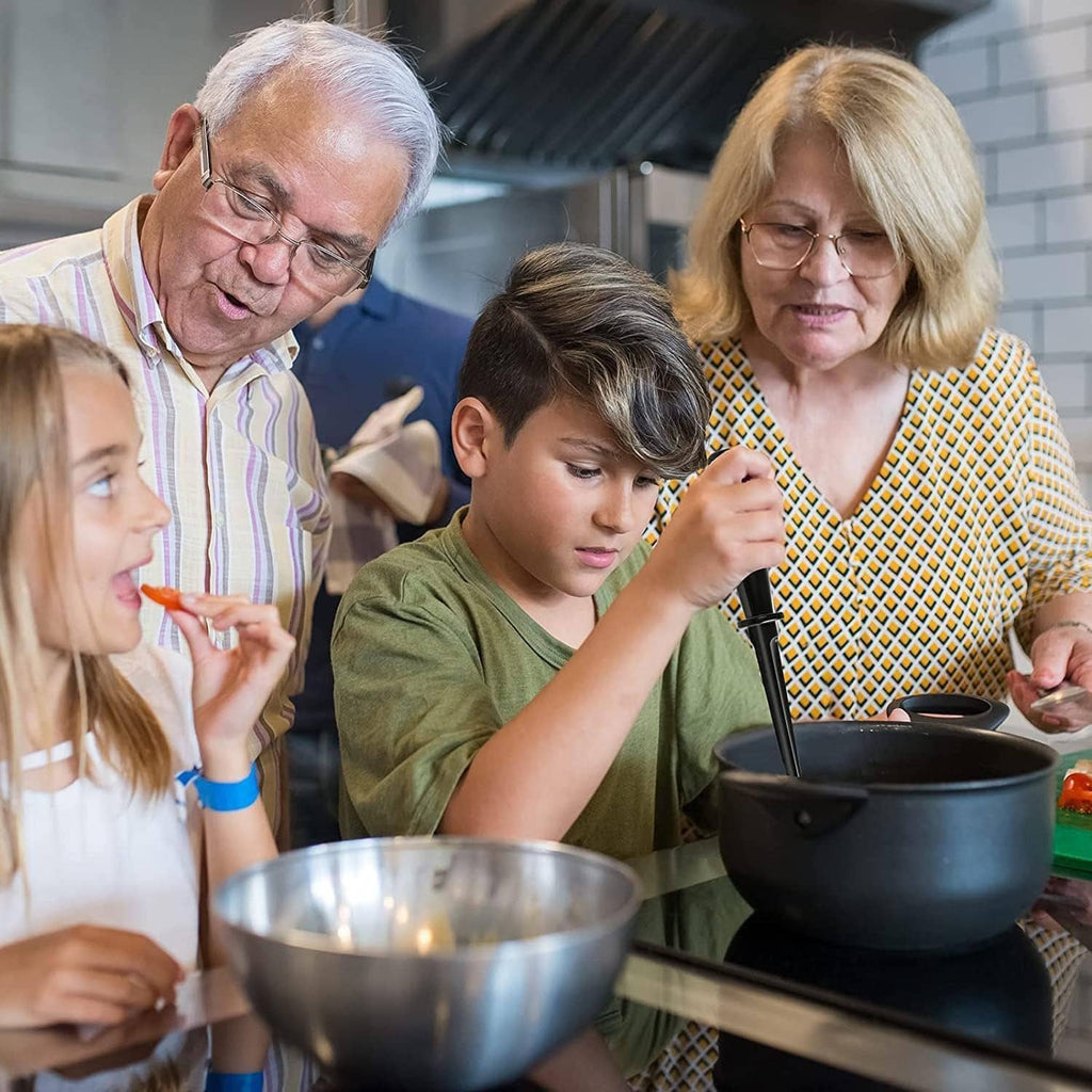 Family using a black masher at a kitchen table with a bowl in front