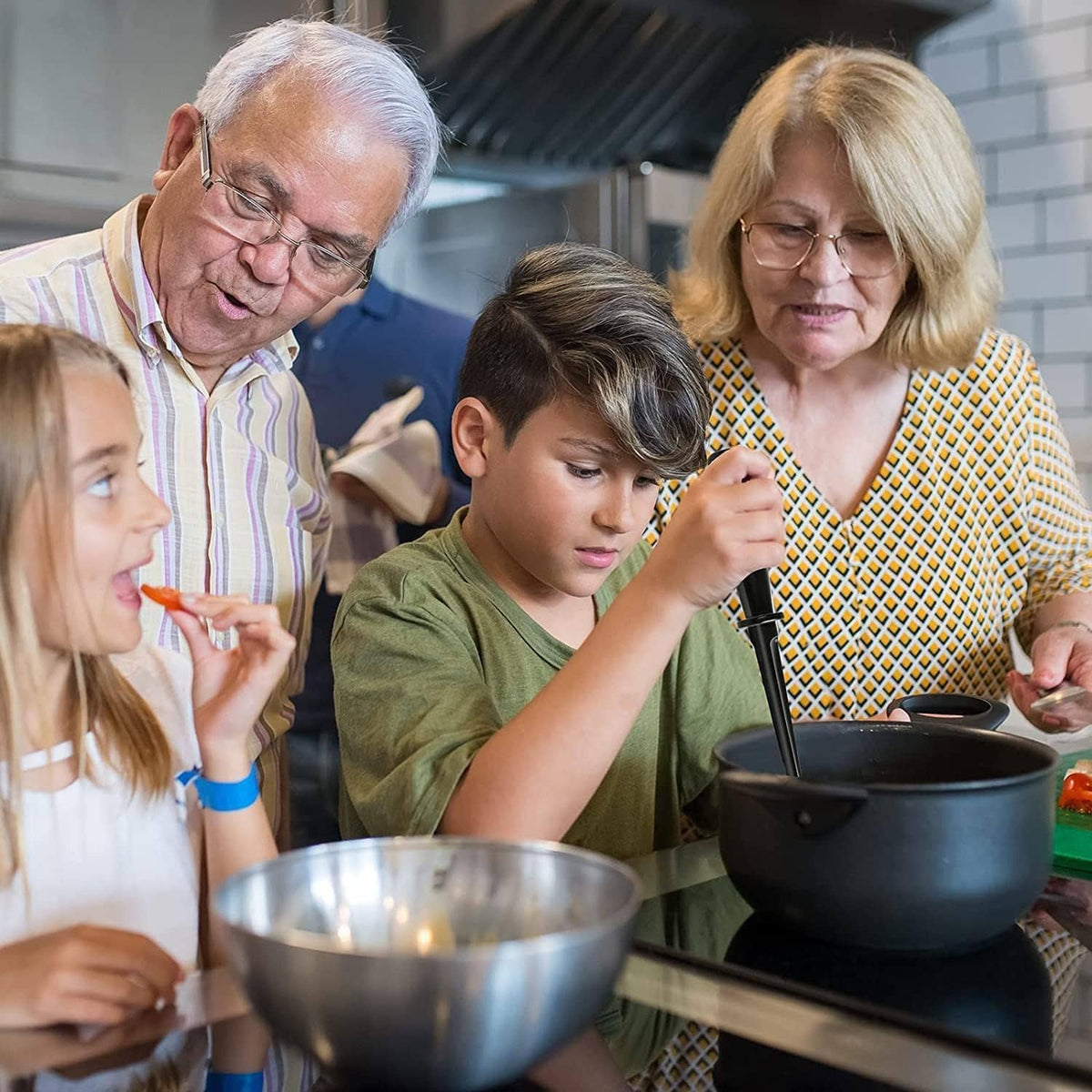 Family using a black masher at a kitchen table with a bowl in front