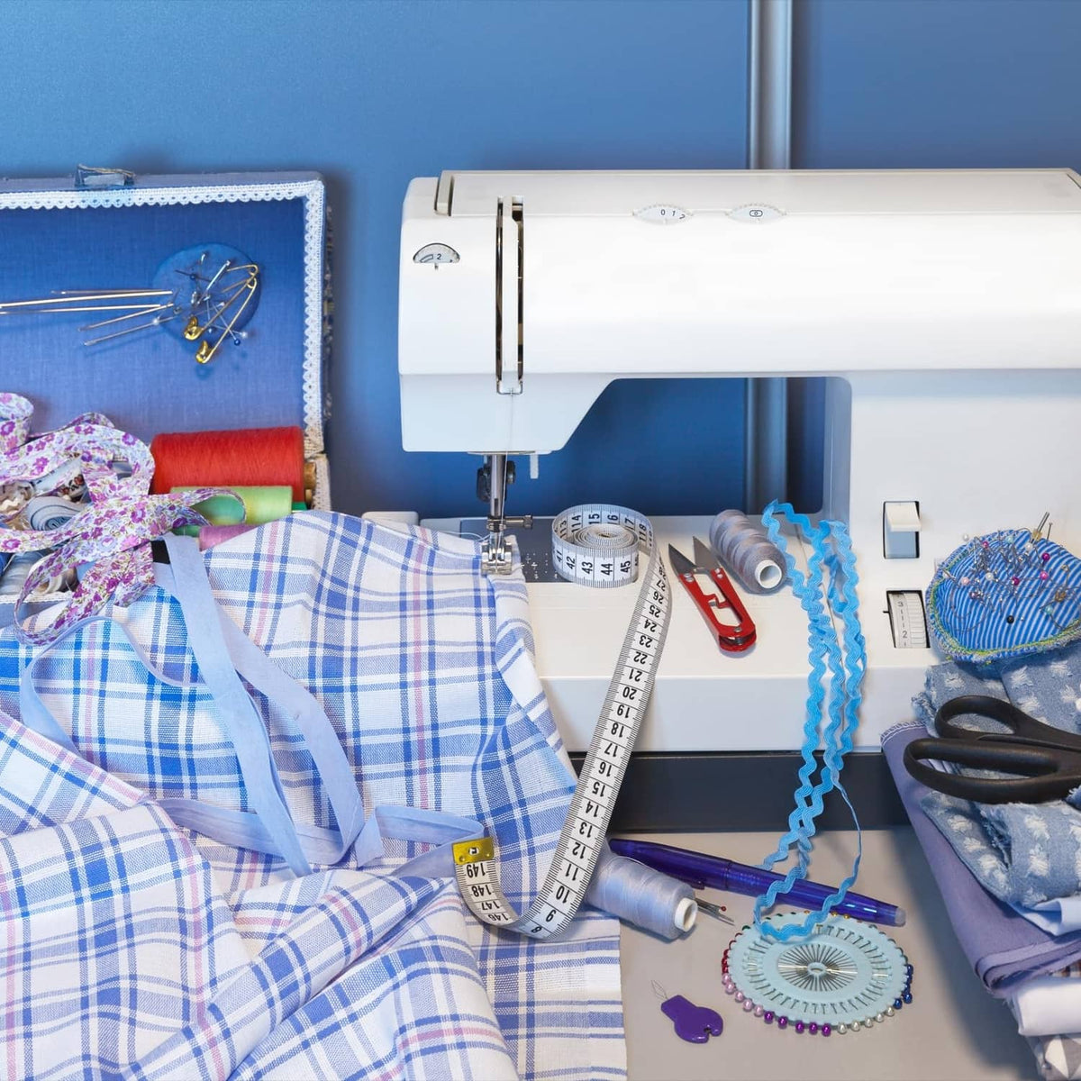 Wine red bias tape spool among sewing supplies beside a sewing machine