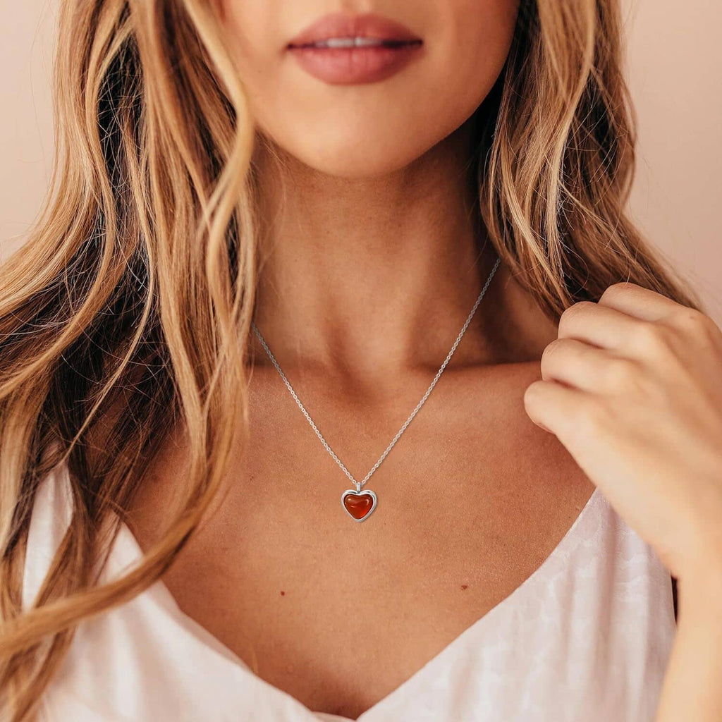 Women’s carnelian heart pendant necklace on silver chain, close to neckline