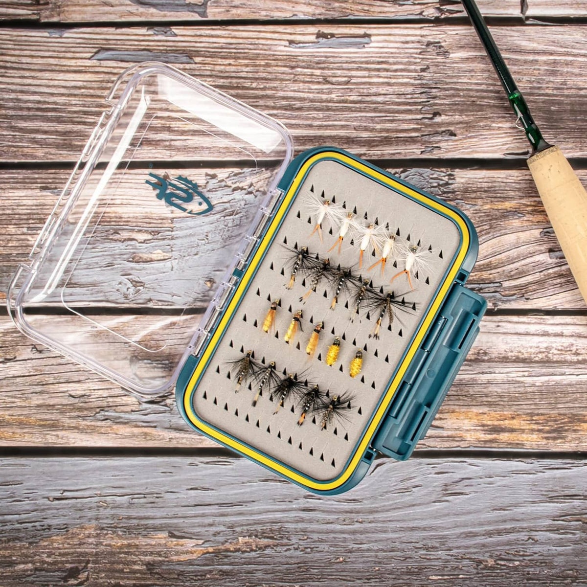 Large waterproof fly box with clear lid open, foam insert holding assorted fishing flies