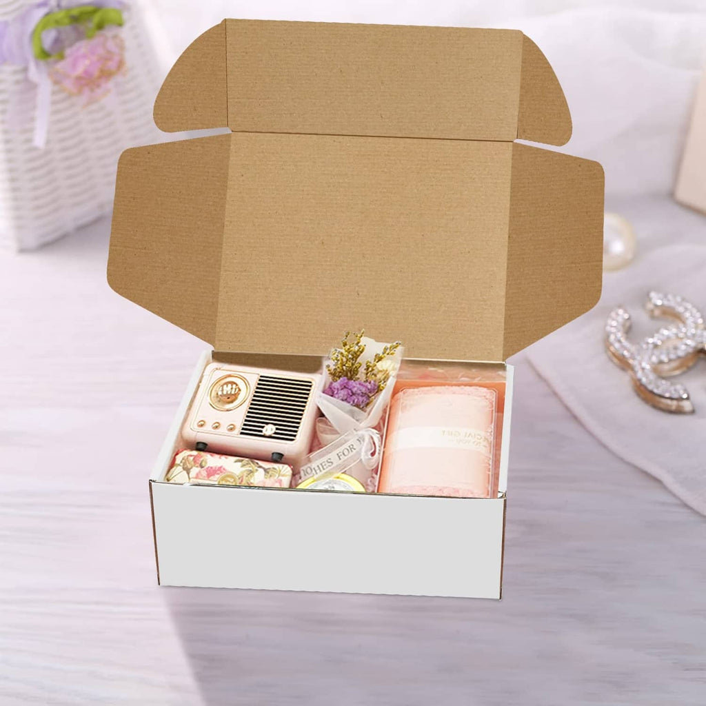 White shipping box with brown corrugated lid open, holding small gift items
