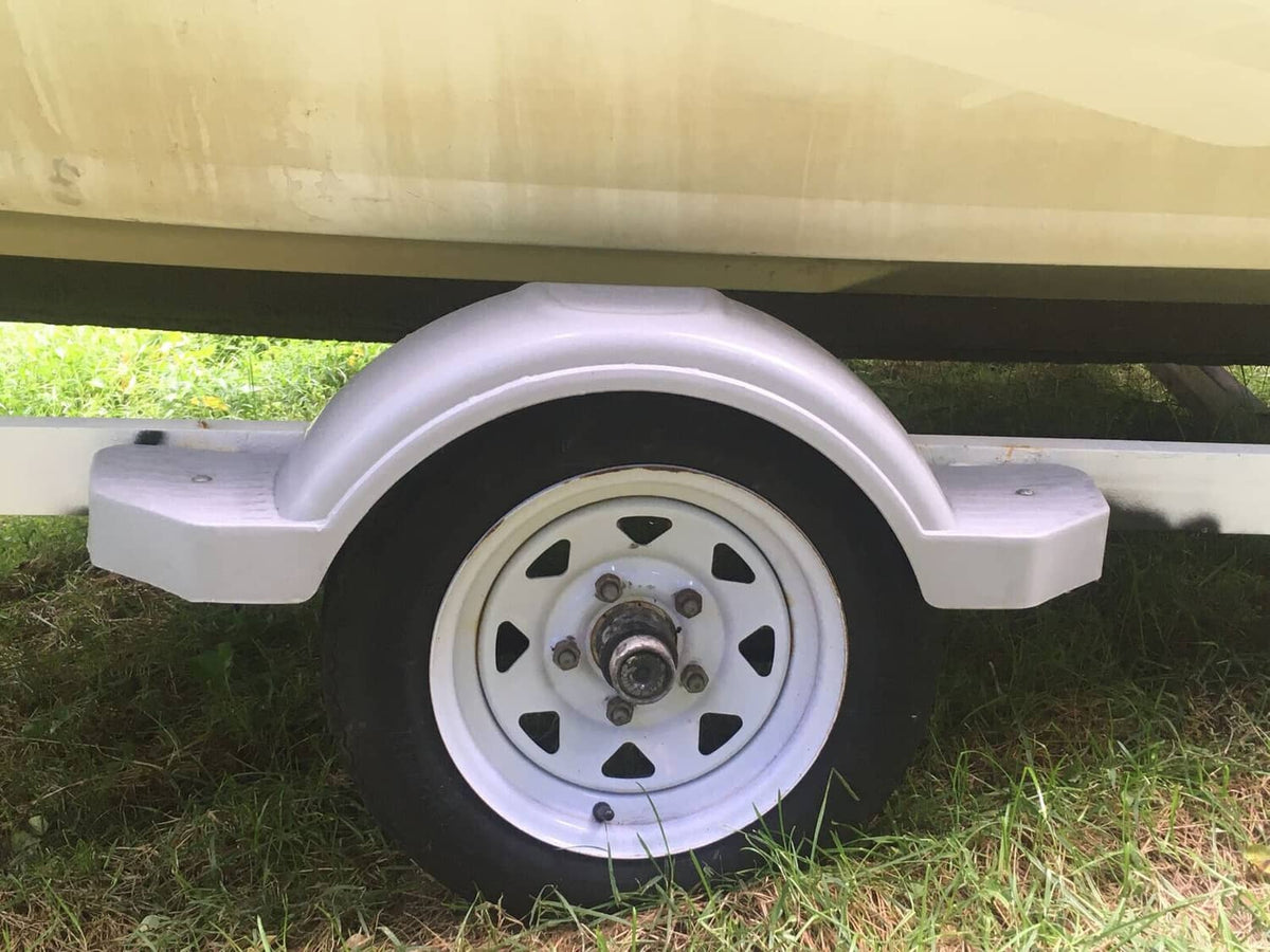 Gray wheel fender step with arched cover mounted on a trailer wheel