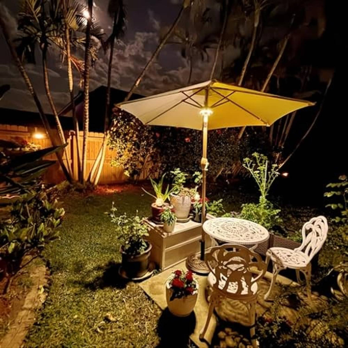 Patio umbrella light on patio umbrella with warm white LEDs in nighttime garden