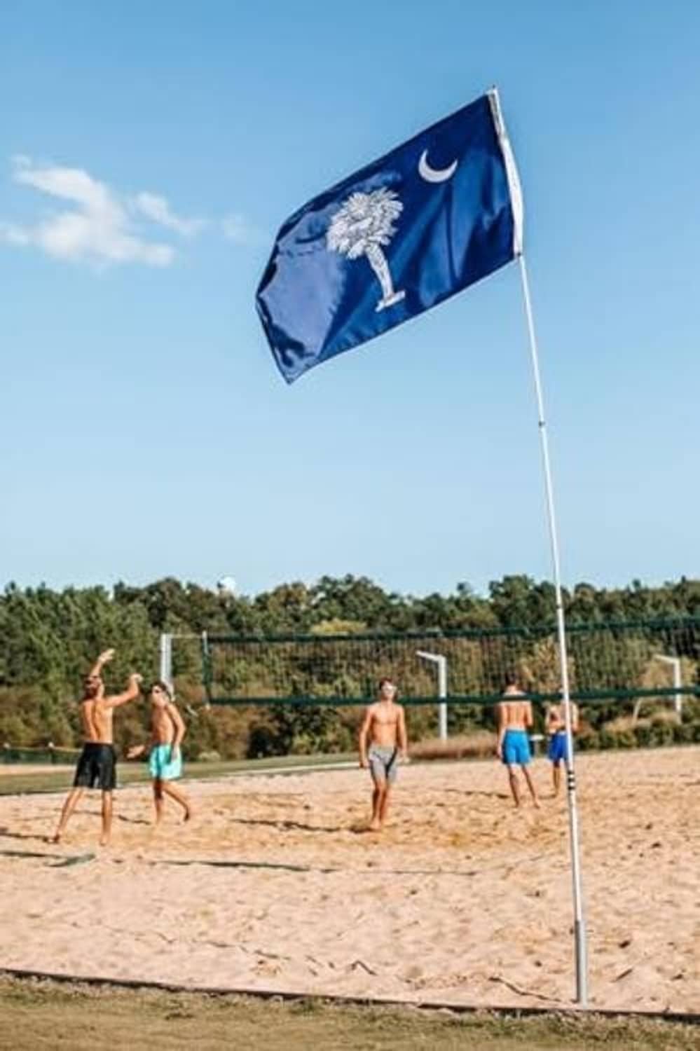 Ground flagpole mount holding a blue flag on a white pole