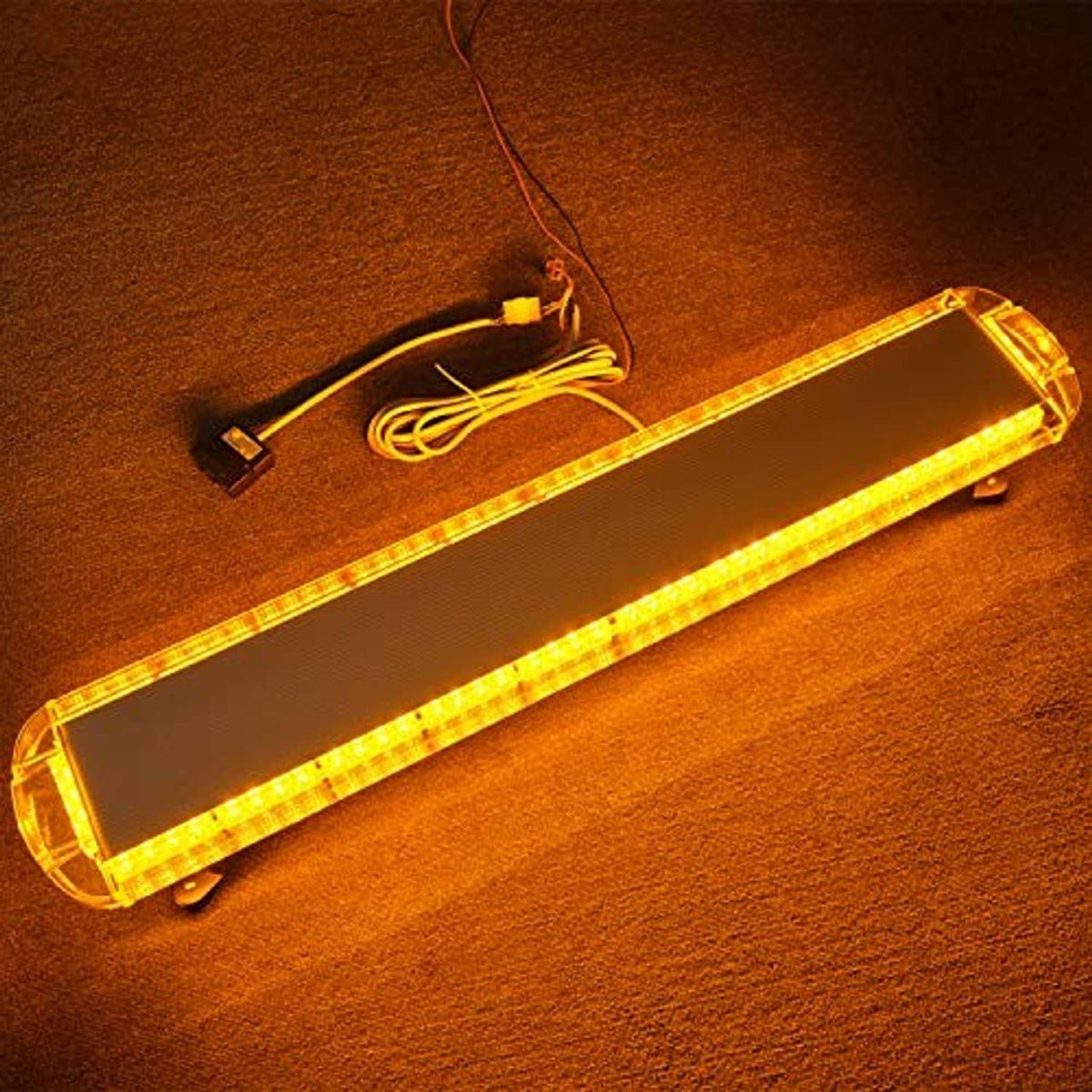 Amber LED strobe light bar glowing, with attached power cable and connector