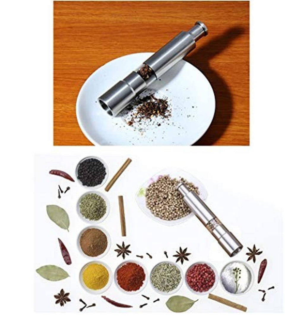 Stainless steel push-button grinder dispensing seasoning onto a white plate
