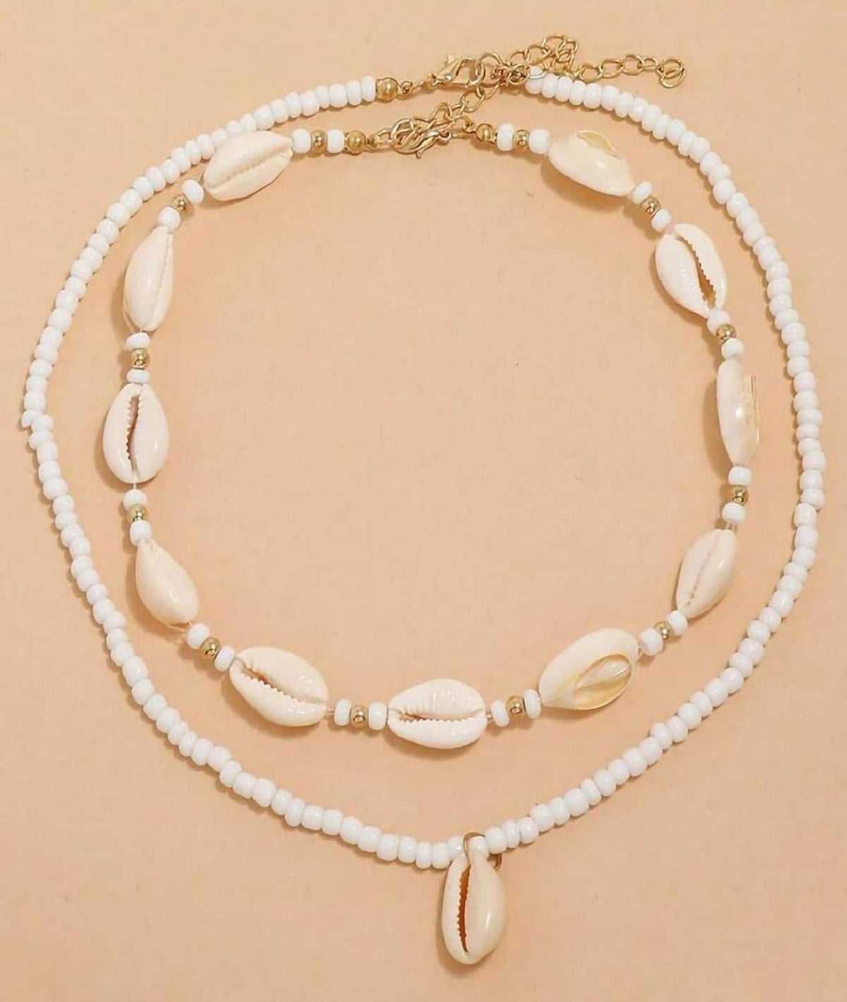 Shell beaded necklace with gold-tone chain and cowrie shells on white bead strands