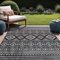 Boho indoor outdoor rug with black-and-white geometric pattern and border fringe