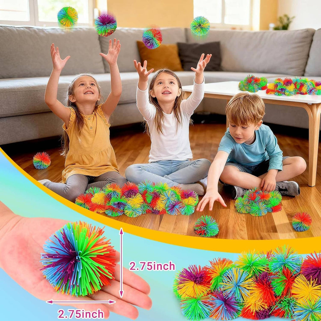 Rainbow stringy pom stress balls on living-room floor, 2.75 inch size