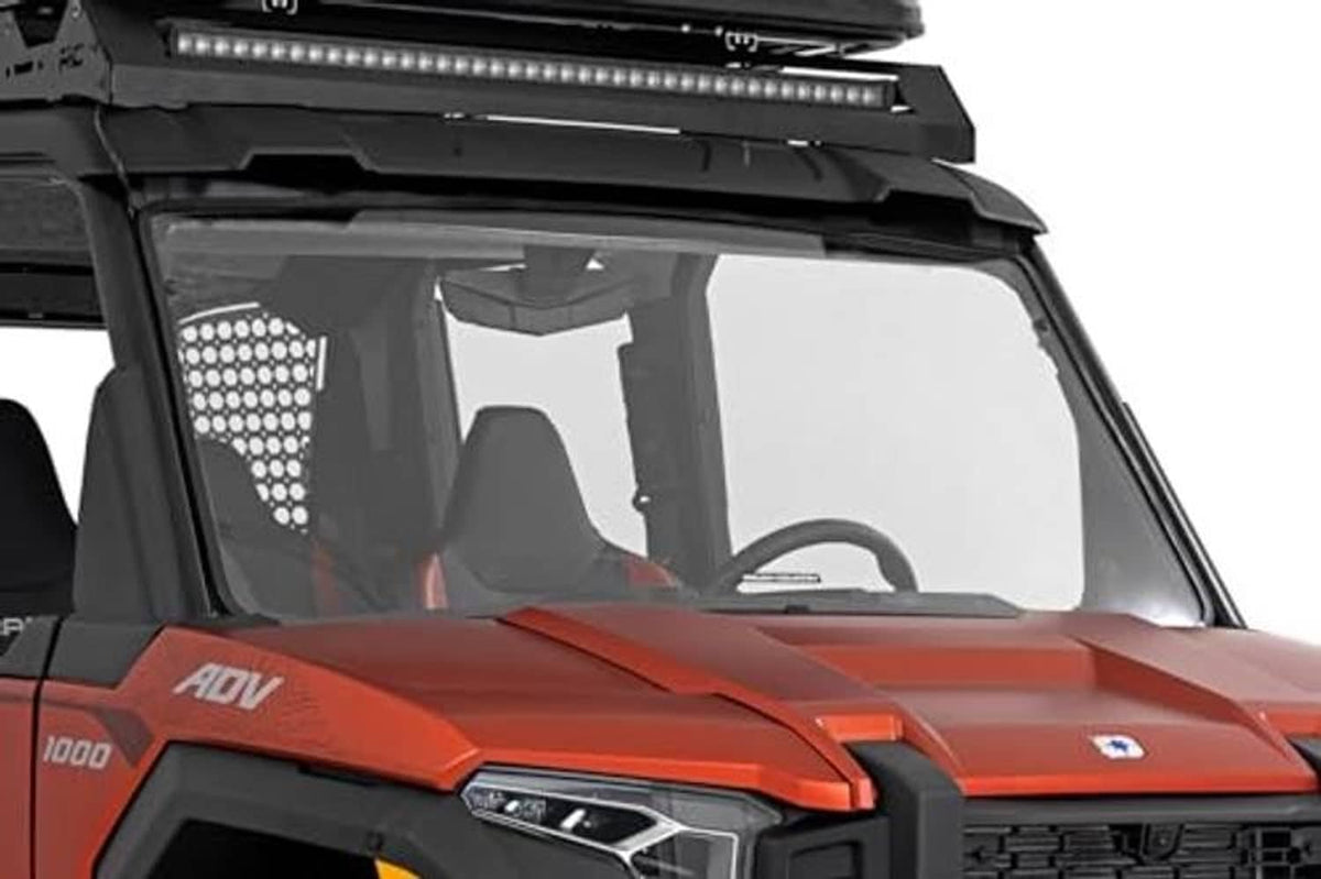 UTV front windshield with clear panel and black frame on orange-and-black vehicle