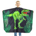 Kids waterproof haircut cape with green dinosaur graphic, black cape with ruffled neck
