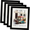 Set of four 8x10 black wood picture frames, stacked with photos in openings