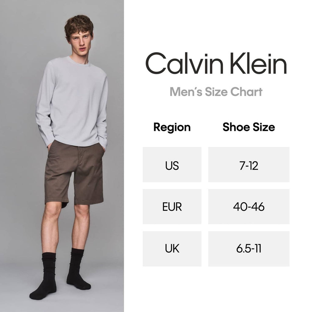 Men's crew socks on model, dark color with Calvin Klein logo at ankle